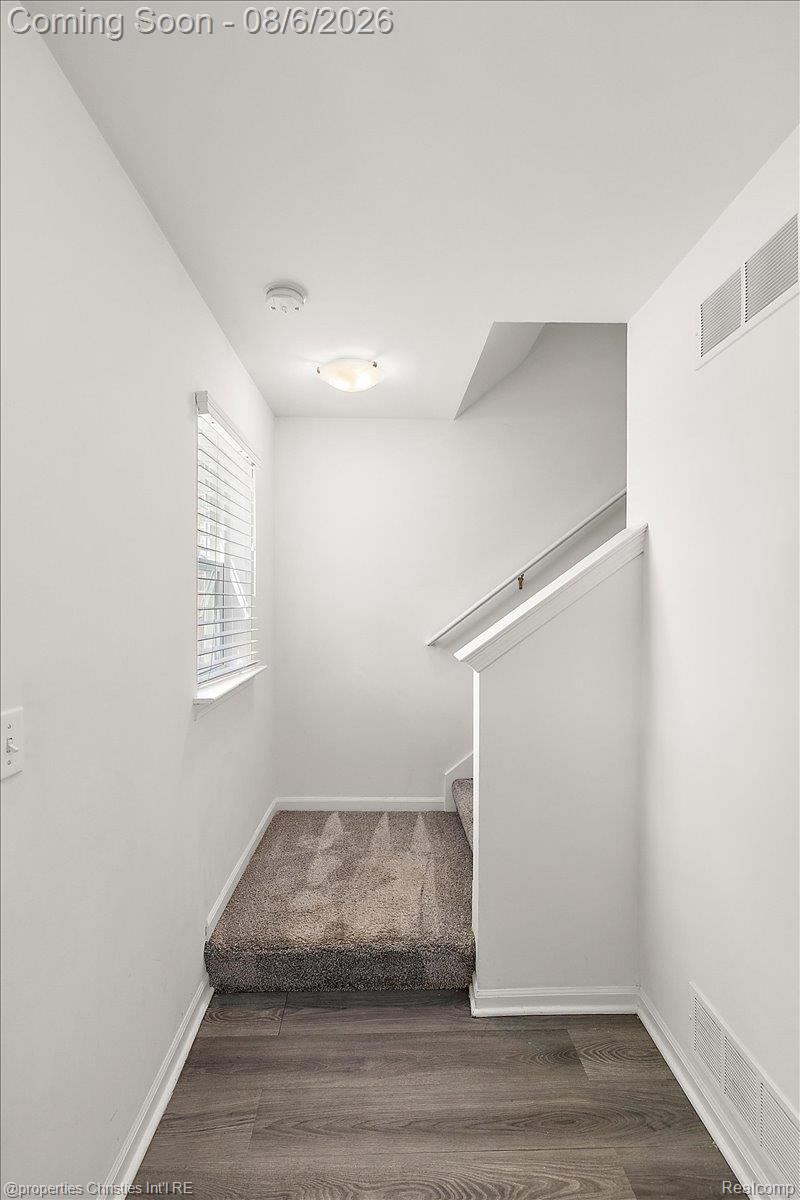 2500 Normandy Road, Unit 38 Royal Oak, MI 48073 - Photo 18 of 55 Carpeted staircase with a wood-finish floor landing, white trim, and a window with blinds