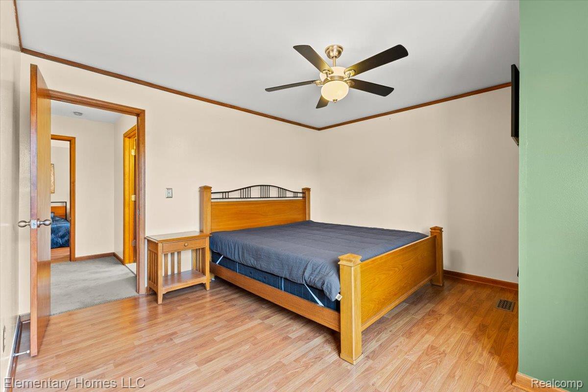 51637 Baker Road New Baltimore, MI 48047 - Photo 36 of 47 Bedroom featuring ornamental molding, light wood finished floors, and ceiling fan