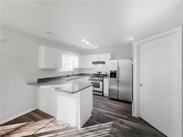 a kitchen with a refrigerator sink and cabinets
