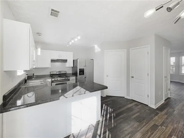 a kitchen with stainless steel appliances a refrigerator a stove a sink and a oven