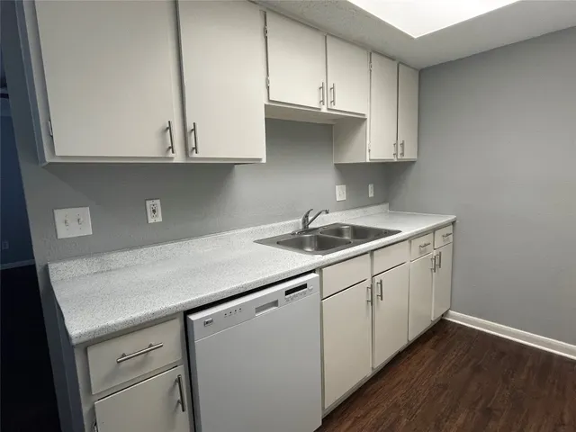 a kitchen with stainless steel appliances granite countertop white cabinets sink and dishwasher