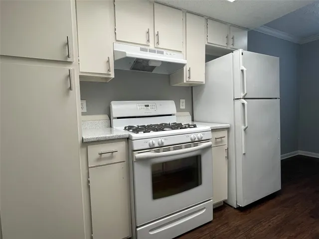 a kitchen with stainless steel appliances white cabinets and a refrigerator