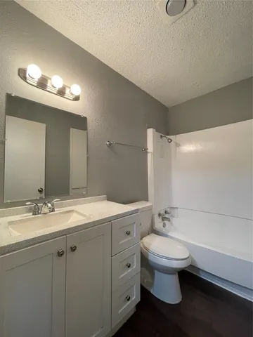 a bathroom with a granite countertop sink mirror and toilet