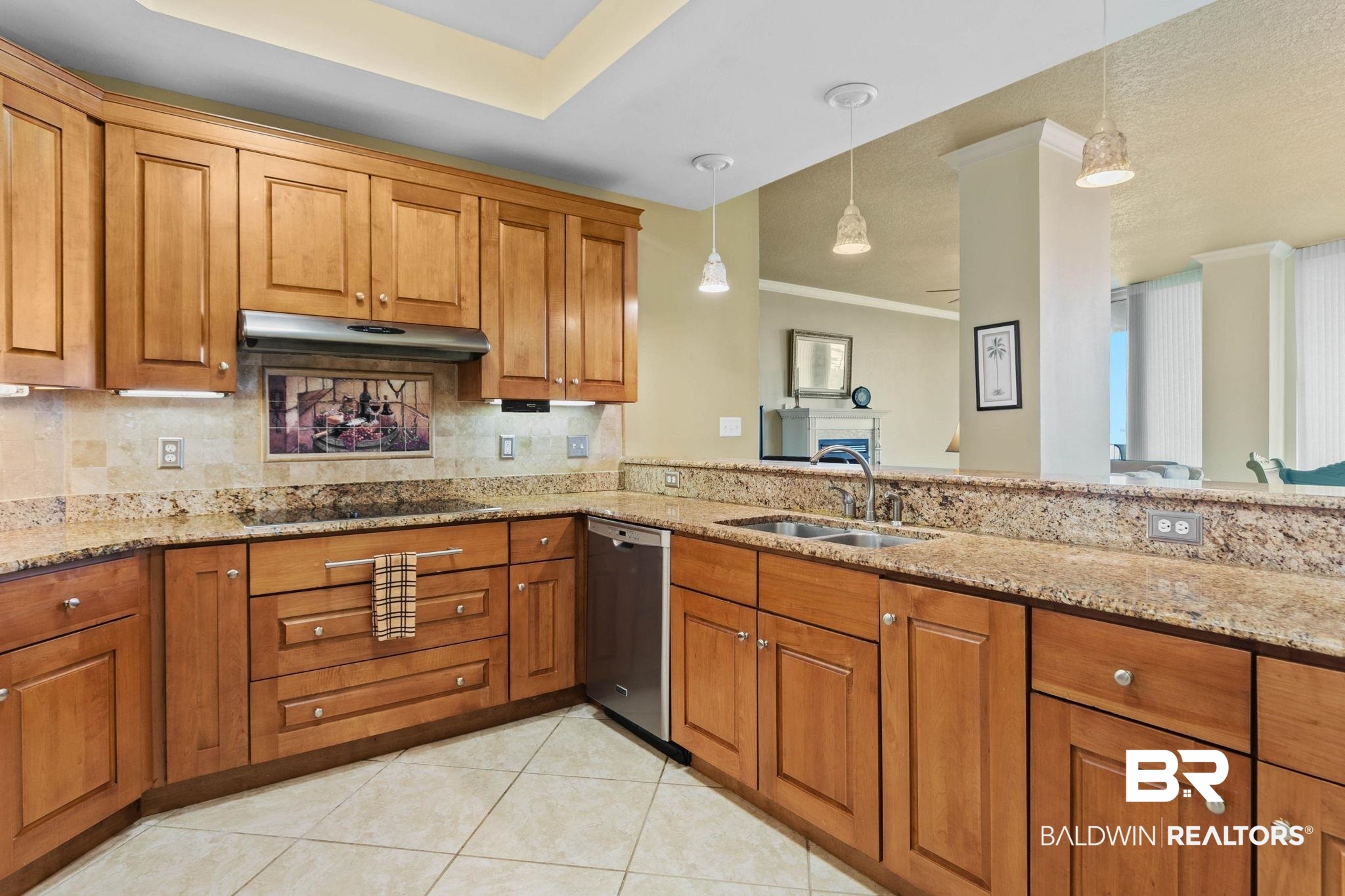 28250 Canal Road, Unit 208 Orange Beach, AL 36561 - Photo 17 of 53 Kitchen with wood finish cabinetry, light stone countertops, ornamental molding, light tile patterned floors, and backsplash