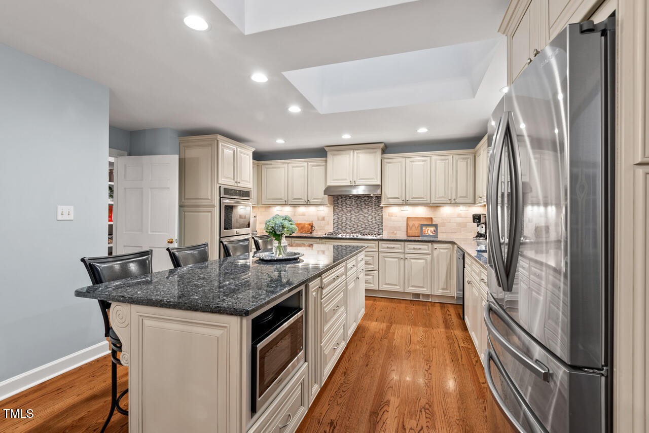 9900 2 Robins Court Raleigh, NC 27613 - Photo 19 of 83 a kitchen with stainless steel appliances granite countertop a refrigerator a stove and a sink