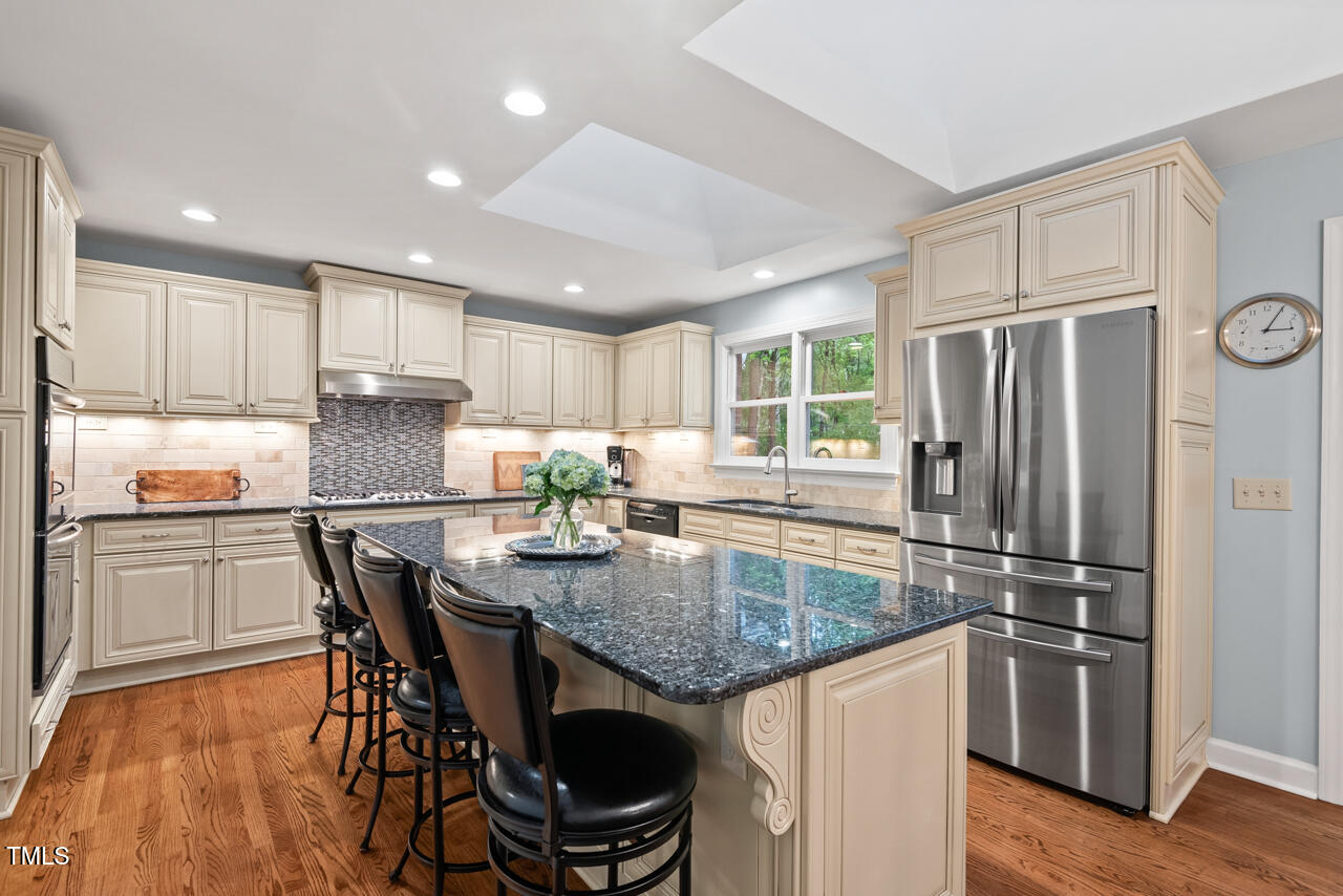 9900 2 Robins Court Raleigh, NC 27613 - Photo 20 of 83 a kitchen with kitchen island a large counter top space and stainless steel appliances