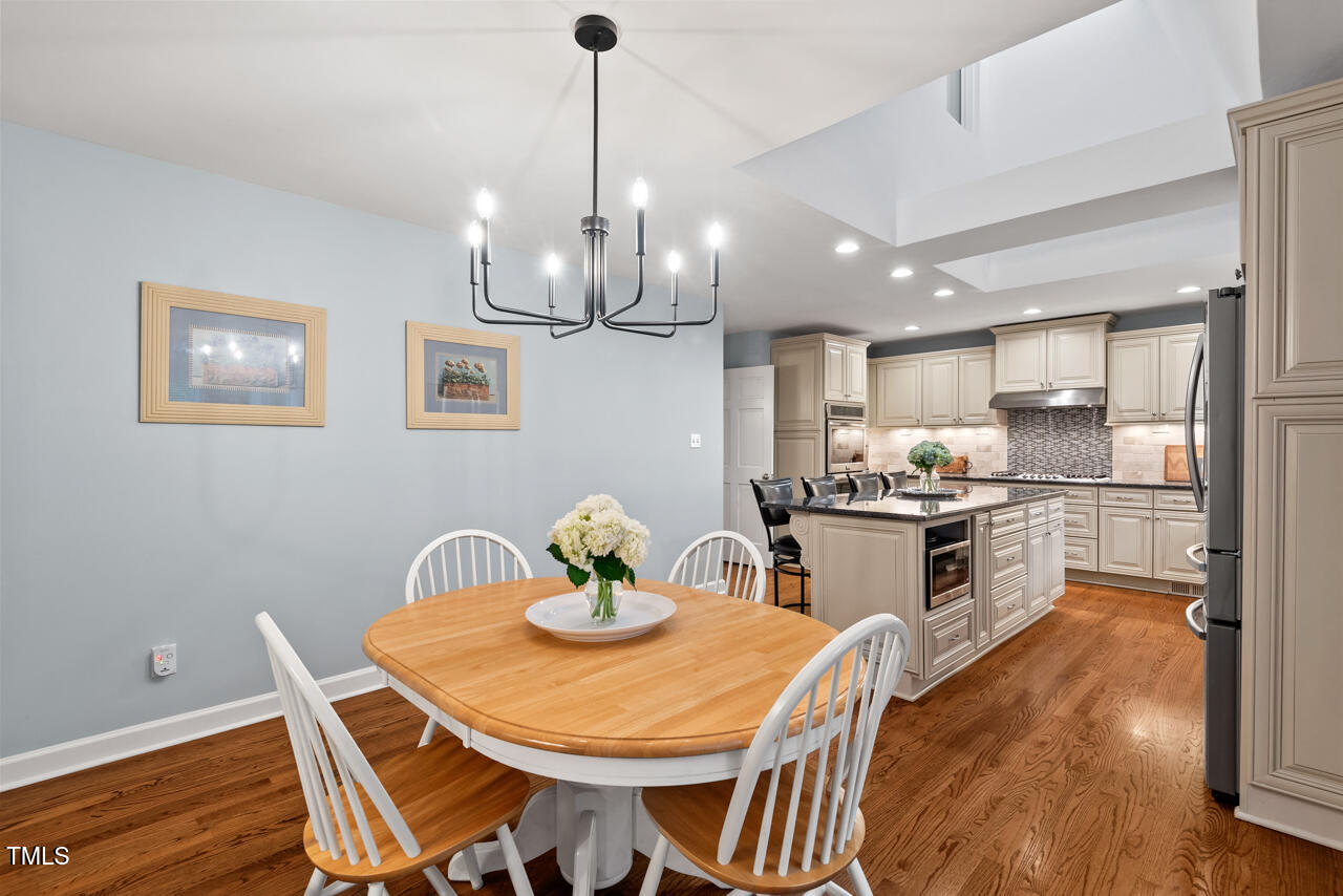 9900 2 Robins Court Raleigh, NC 27613 - Photo 26 of 83 a kitchen with stainless steel appliances kitchen island granite countertop a dining table chairs and stove