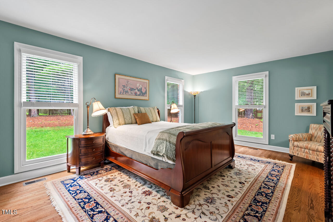 9900 2 Robins Court Raleigh, NC 27613 - Photo 39 of 83 a bedroom with wooden floor and a window