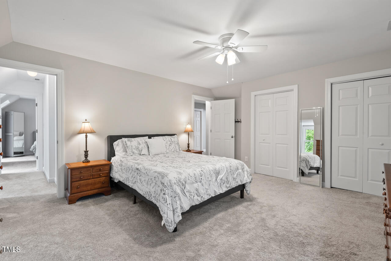 9900 2 Robins Court Raleigh, NC 27613 - Photo 61 of 83 a spacious bedroom with a bed and a chandelier