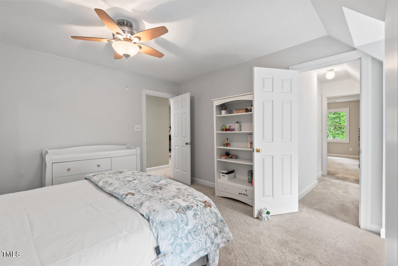 9900 2 Robins Court Raleigh, NC 27613 - Photo 65 of 83 a bedroom with a bed and a chandelier