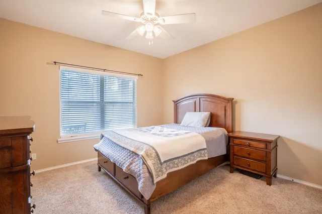 a bedroom with a bed next to a window and a chandelier
