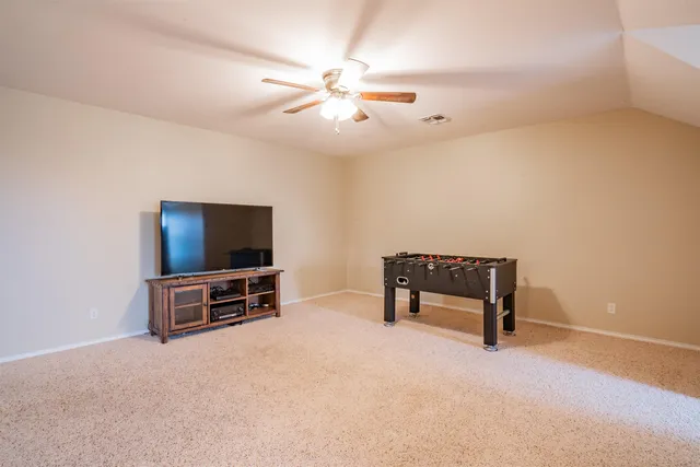 an empty room with furniture and a flat screen tv