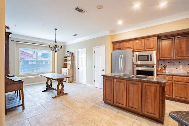 a open kitchen with stainless steel appliances granite countertop a sink dishwasher and cabinets with wooden floor