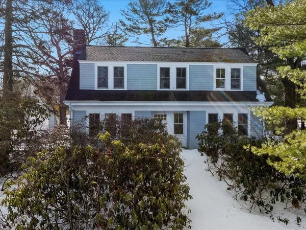 a front view of house with yard and trees around