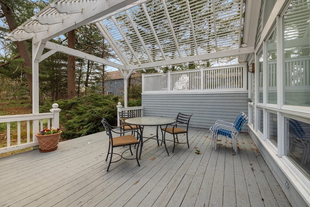 207 Pleasant Street Milton, MA 02186 - Photo 24 of 28 a view of a patio with table and chairs and wooden floor