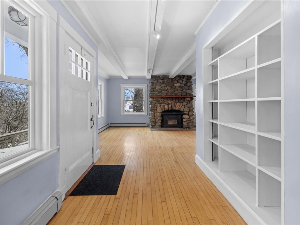 207 Pleasant Street Milton, MA 02186 - Photo 3 of 28 a view of main area with wooden floor fireplace and windows