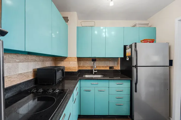 a kitchen with a refrigerator and a stove top oven