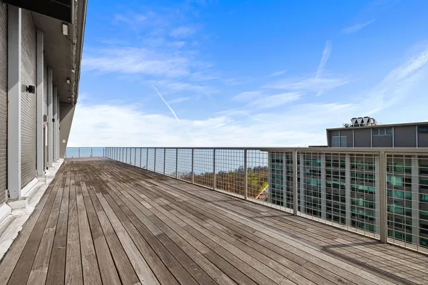 a view of balcony with wooden floor and fence