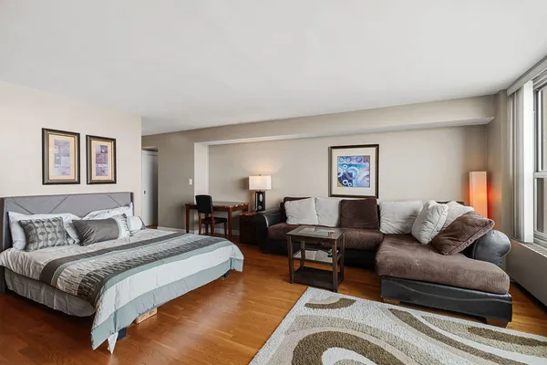 a spacious bedroom with a bed couch and a window