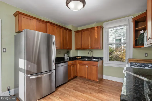 a kitchen with stainless steel appliances granite countertop a refrigerator stove top oven and sink