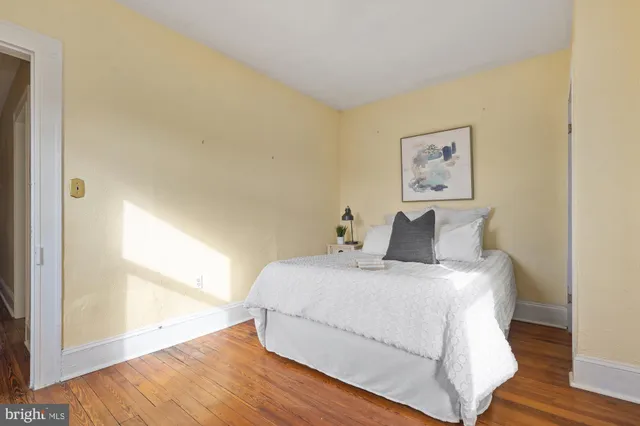 a view of a bedroom with wooden floor and bed