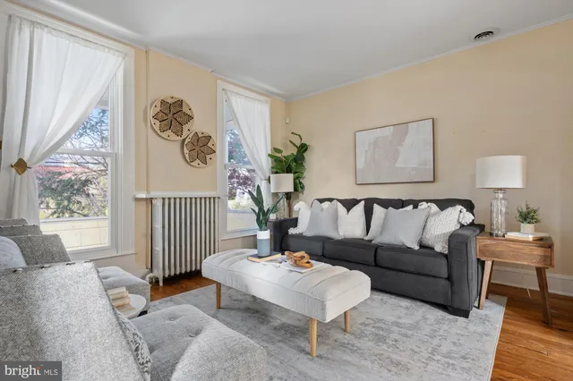 a living room with furniture and paintings on the wall