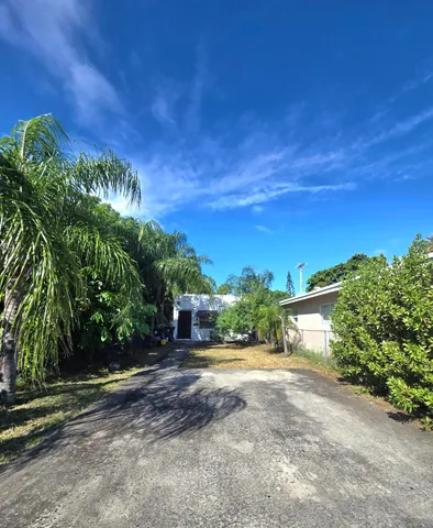 a view of a yard with flower plants and wooden fence