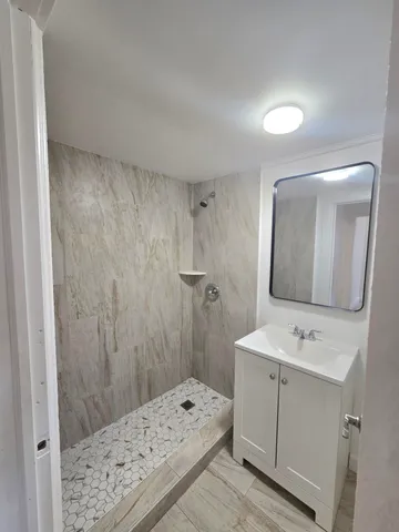 a bathroom with a sink a shower and a mirror