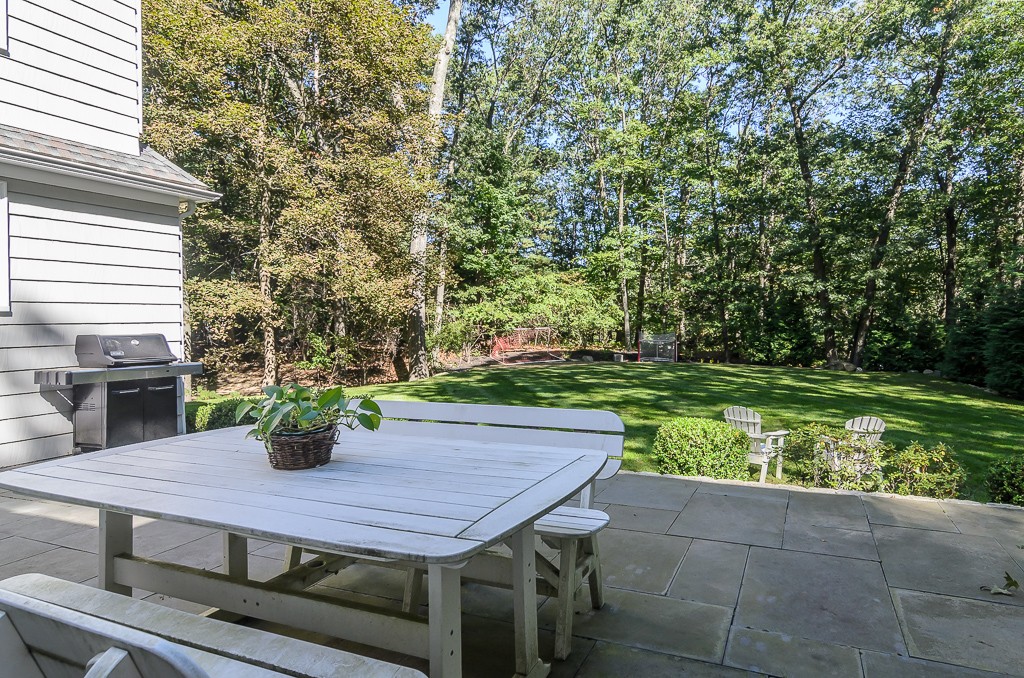 82 Whittier Road Wellesley, MA 02481 - Photo 25 of 28 a view of a backyard with table and chairs potted plants and large tree