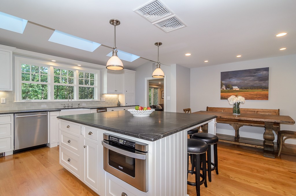82 Whittier Road Wellesley, MA 02481 - Photo 6 of 28 a kitchen with stainless steel appliances granite countertop a stove a sink a dining table and chairs with wooden floor