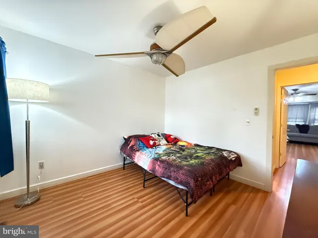 a bedroom with a bed and a potted plant on the dresser