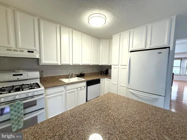 a kitchen with a refrigerator and a stove top oven