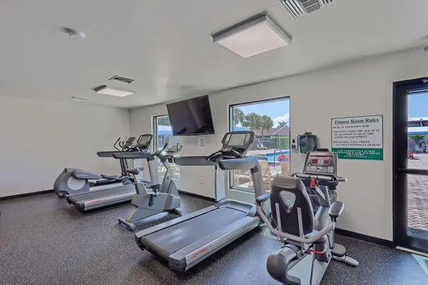 a living room with furniture a rug and gym equipment
