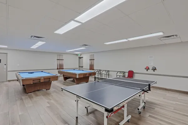 a room with furniture pool table and wooden floor