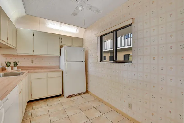 a kitchen with white cabinets and white appliances