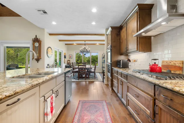 a kitchen with stainless steel appliances granite countertop lots of counter top space and wooden floor