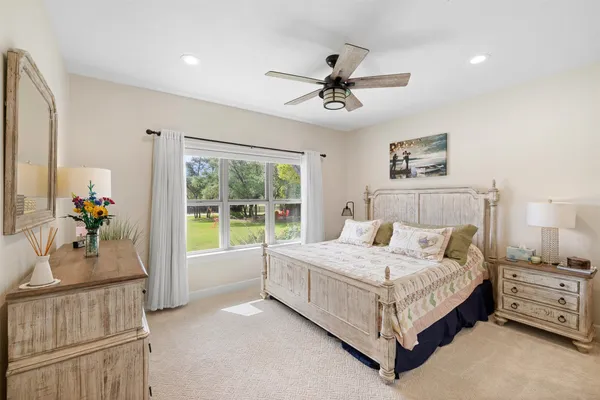 a large bedroom with a large bed and a chandelier fan