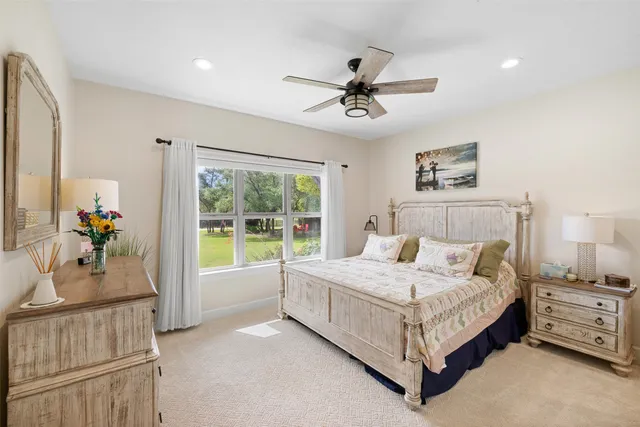 a large bedroom with a large bed and a chandelier fan
