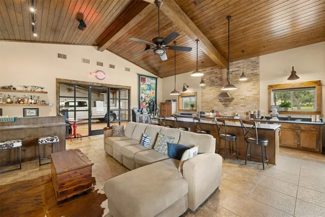 a living room with furniture a chandelier and a dining table