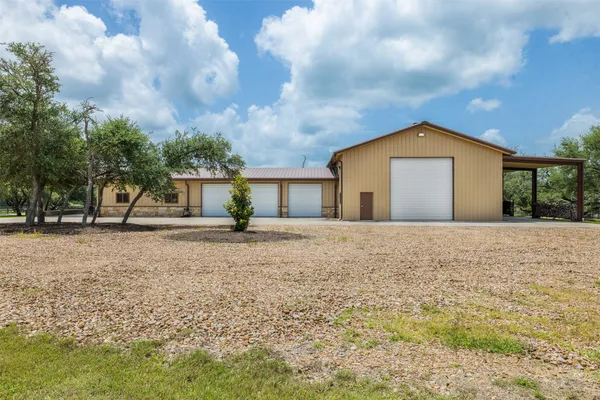 a front view of a house with a yard and trees