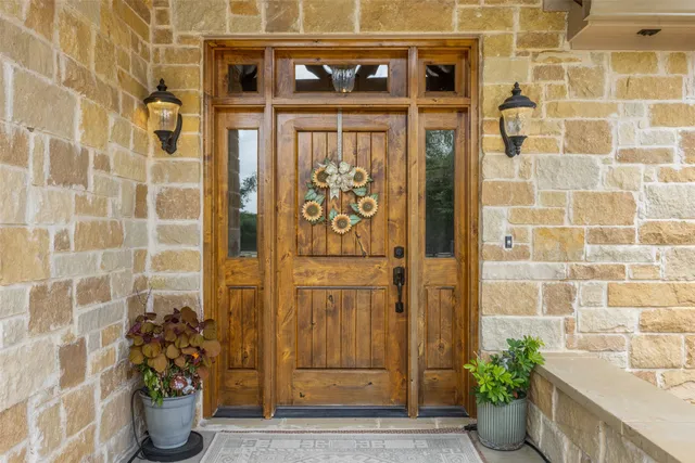 a view of front door of house and potted plants