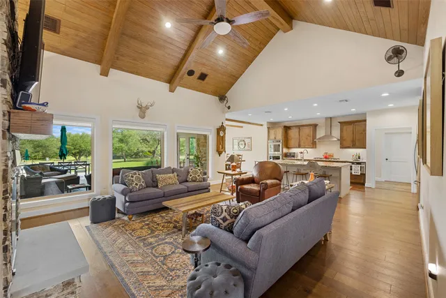 a living room with furniture kitchen and a large window