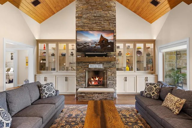 a living room with furniture a flat screen tv and a fireplace