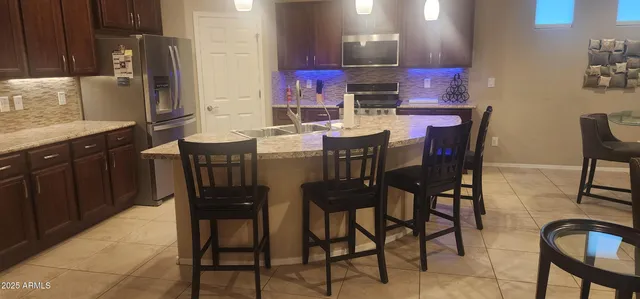 a dining table with chairs and kitchen view