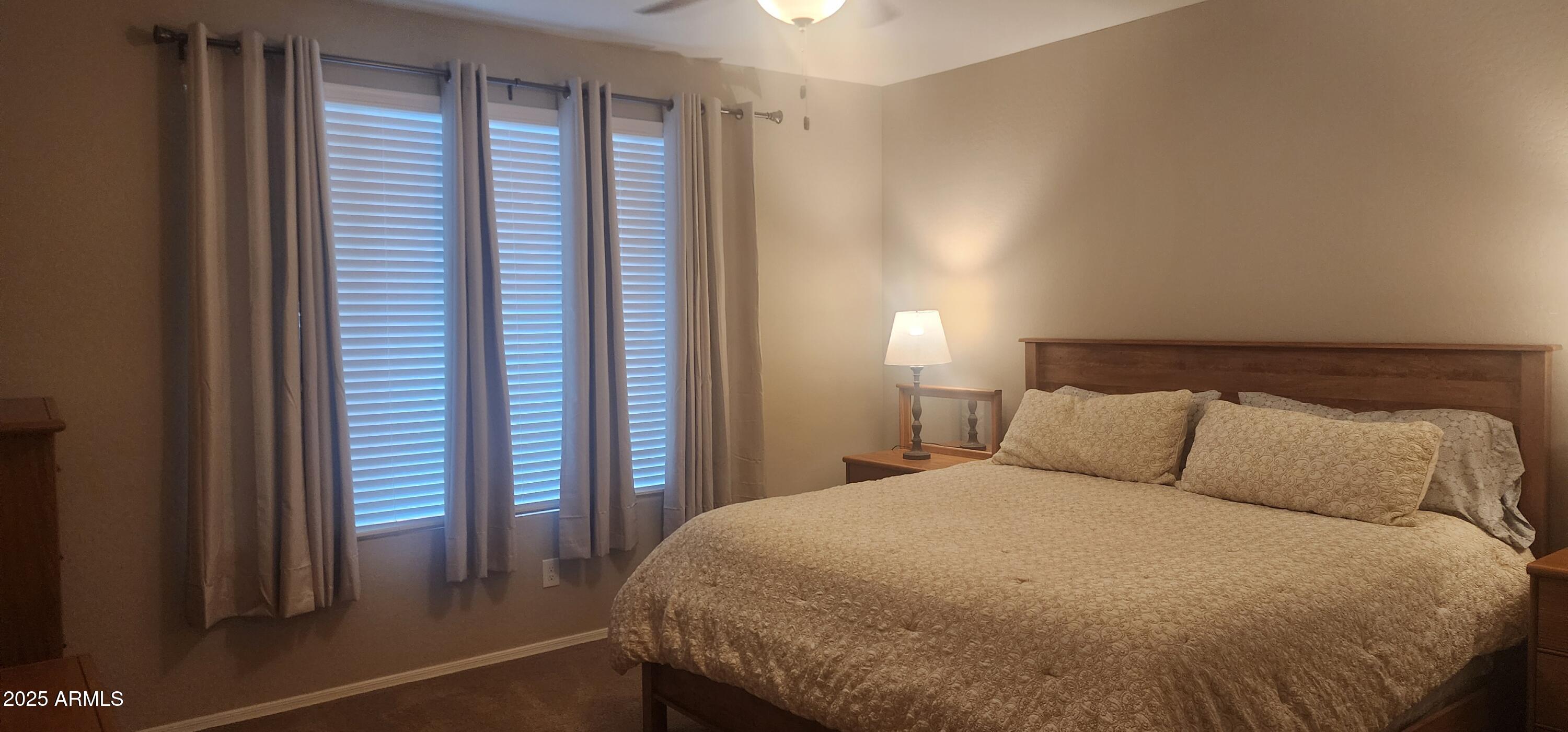 20602 North 274th Avenue Buckeye, AZ 85396 - Photo 6 of 22 a bed sitting in a bedroom next to a window and a chair