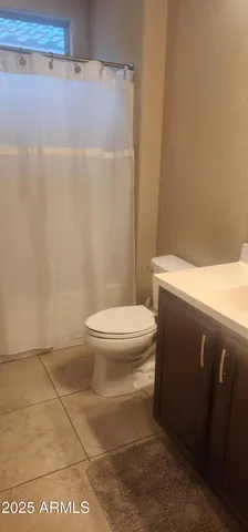 a white toilet sitting next to a shower