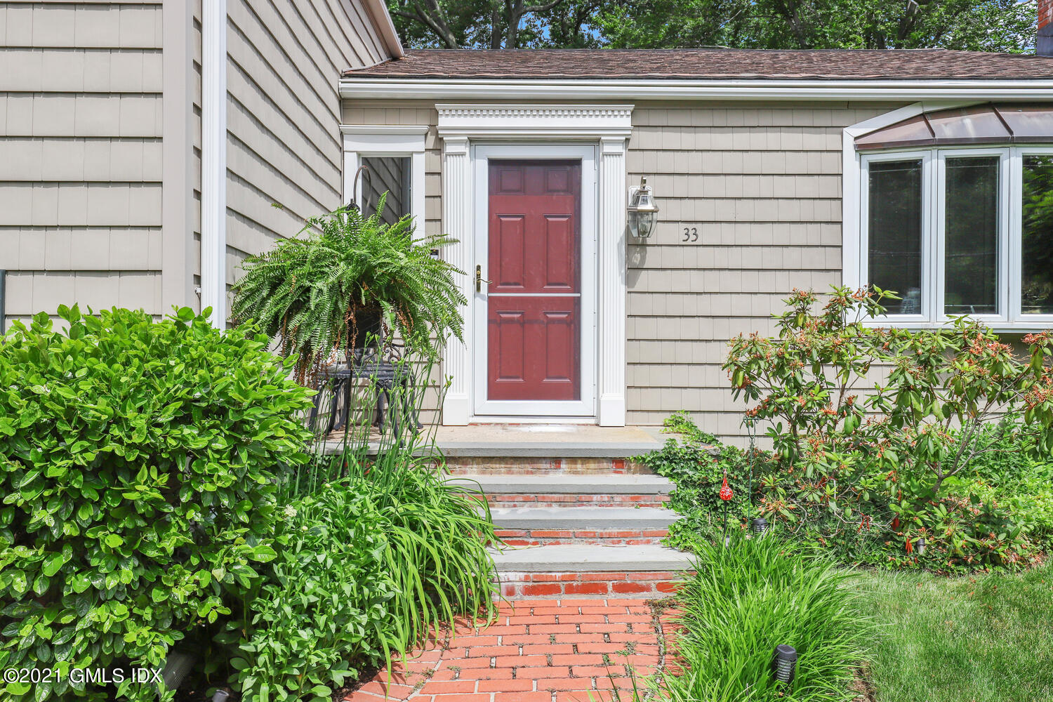 33 Mary Lane Riverside, CT 06878 - Photo 2 of 34 a potted plant in front of a house