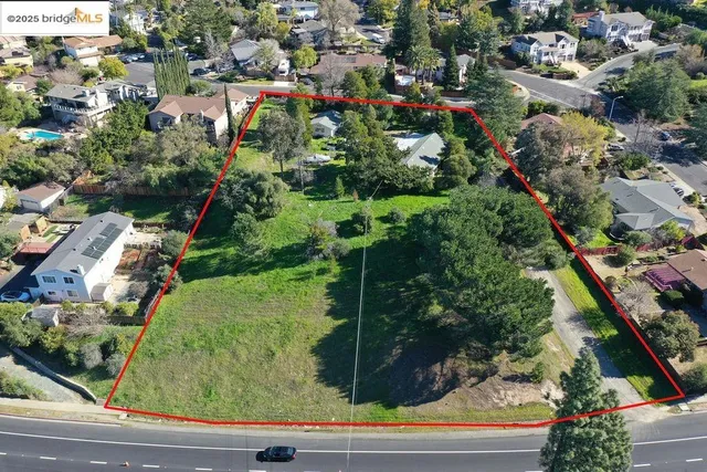 an aerial view of residential houses with outdoor space and street view