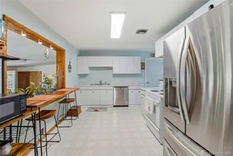 a kitchen with white cabinets and stainless steel appliances
