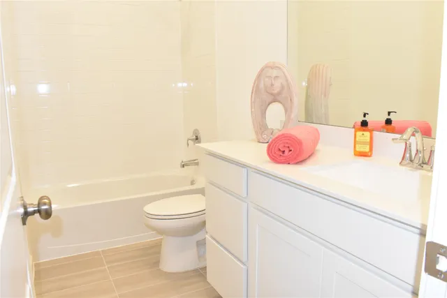 a bathroom with a sink mirror vanity and toilet